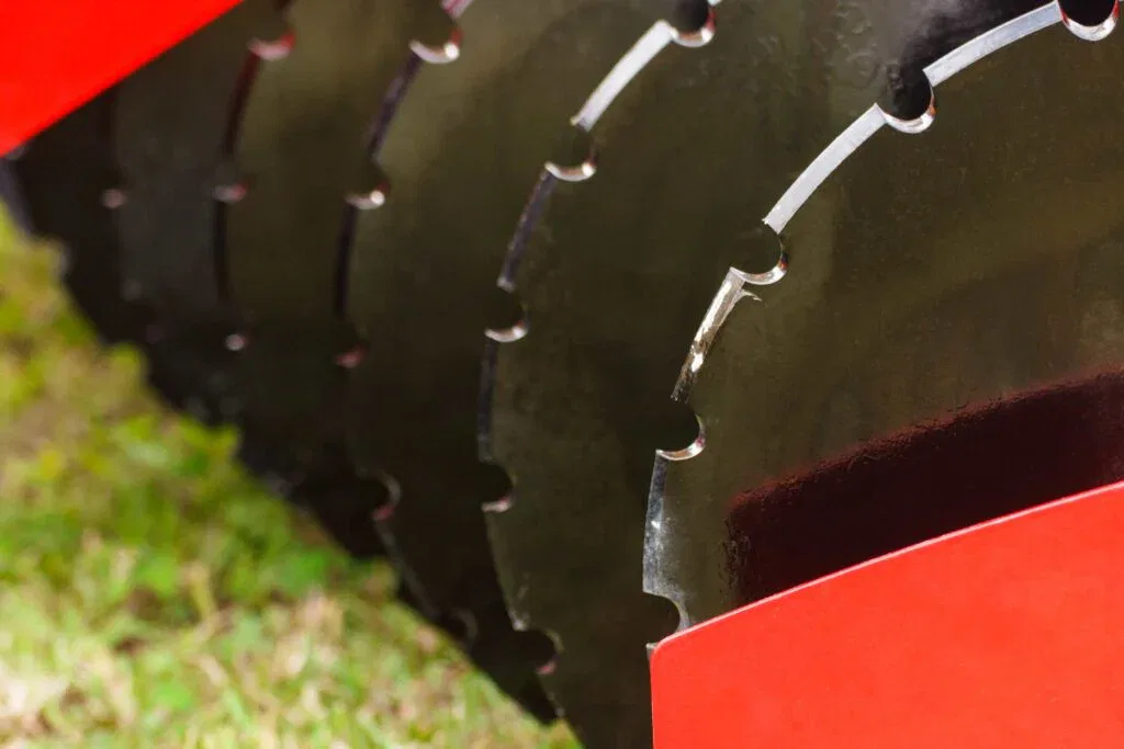 Close-up of sharp, notched tillage discs on professional agricultural equipment, providing expert soil preparation service in Ocala, Florida.