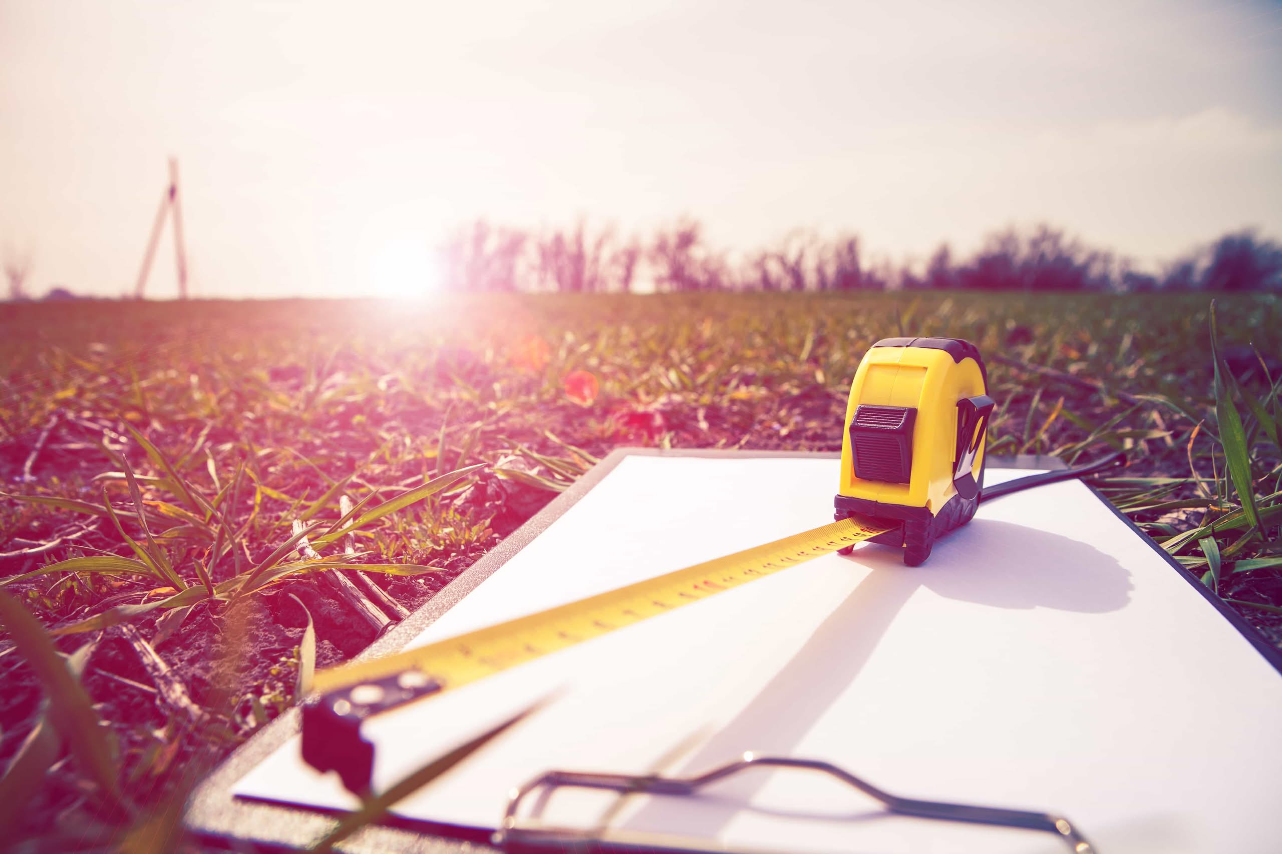 Measuring tools on a clipboard in a field for professional commercial acreage monitoring and land assessment in Ocala, FL.